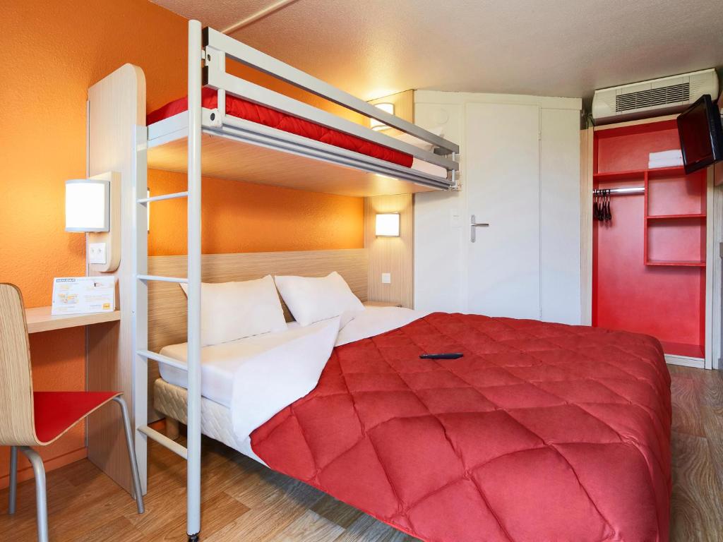 - une chambre avec des lits superposés et un couvre-lit rouge dans l'établissement Premiere Classe Lyon Ouest - Tassin, à Tassin-la-Demi-Lune