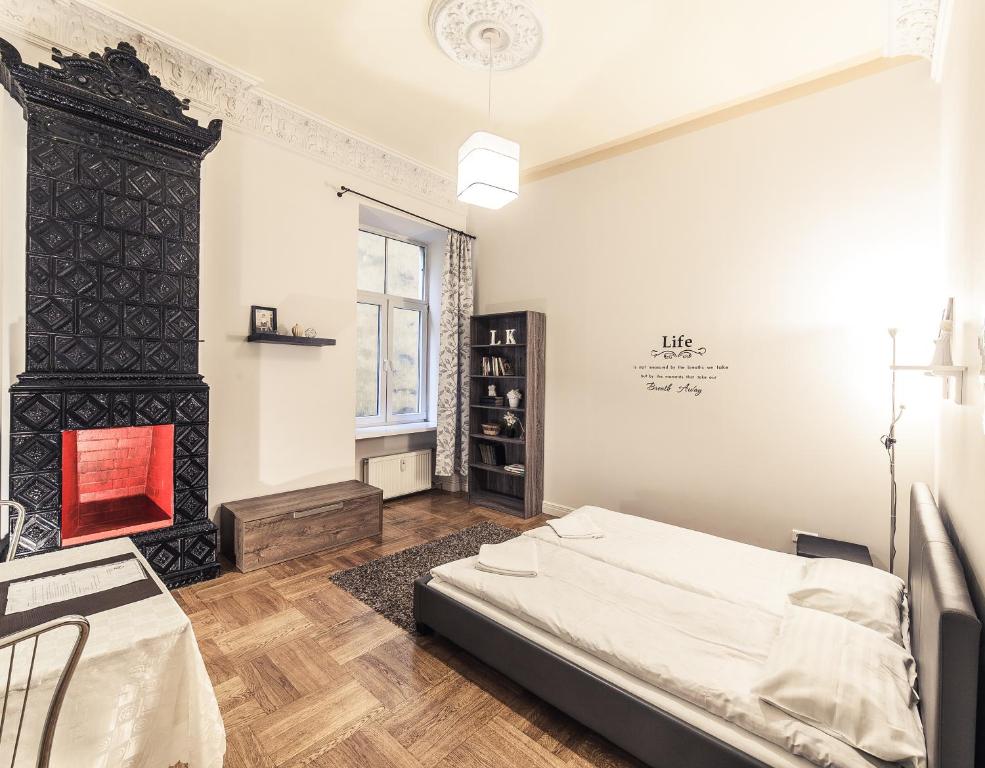 1 dormitorio con 1 cama y chimenea en Mosaic Center Apartments en Riga