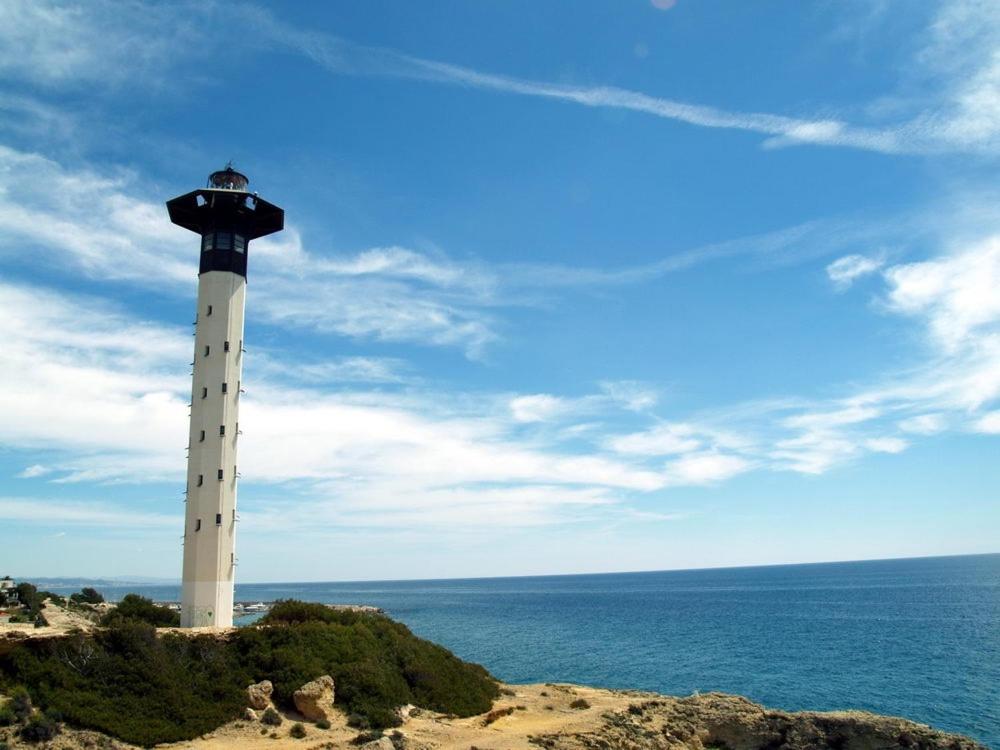 a lighthouse sitting on top of a hill next to the ocean at Apartamento Estació in Torredembarra