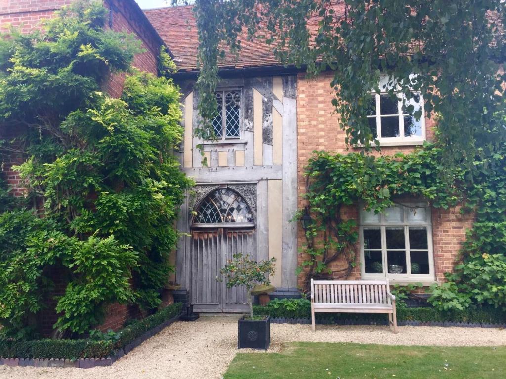 un edificio con un banco delante de él en White Hall Farm, en Leamington Spa