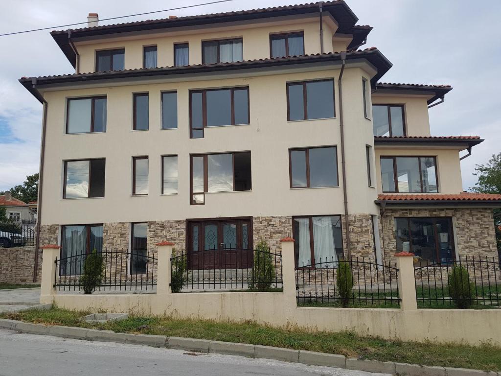 une grande maison avec une clôture devant elle dans l'établissement Apartments Stefanov in Byala, à Byala
