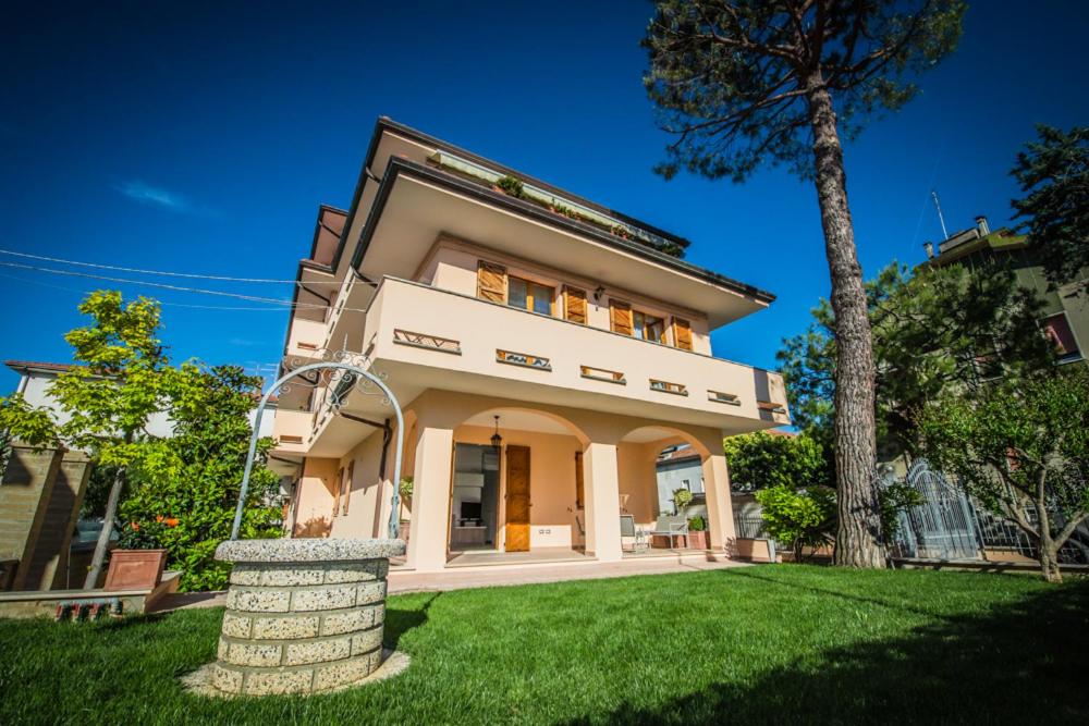 una casa grande con un césped verde delante de ella en Appartamenti vicino al mare, en Civitanova Marche