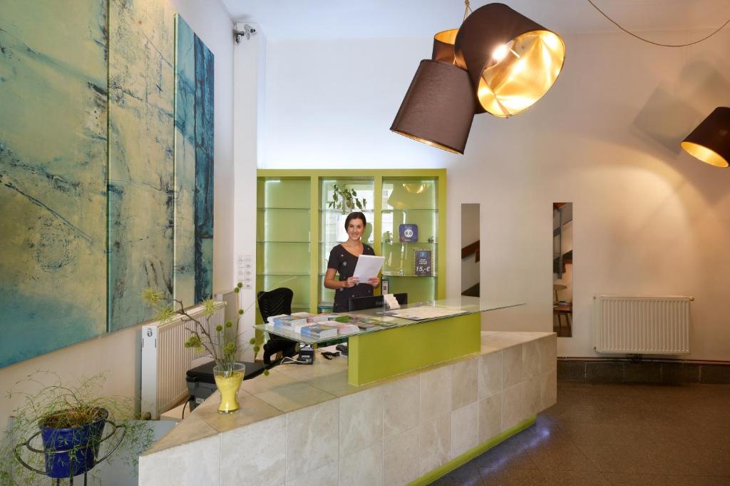 um escritório com uma mulher sentada numa secretária em Hotel Mocca em Viena
