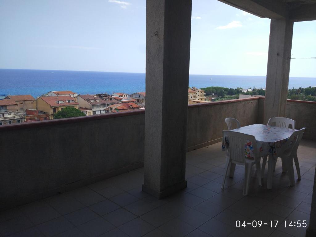 a balcony with a table and chairs and the ocean at Villa Spaia in Brancaleone Marina