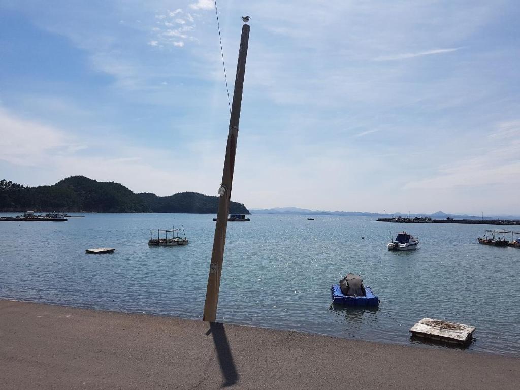 un poste en medio de un cuerpo de agua con barcos en Uwha Minbak en Yeosu