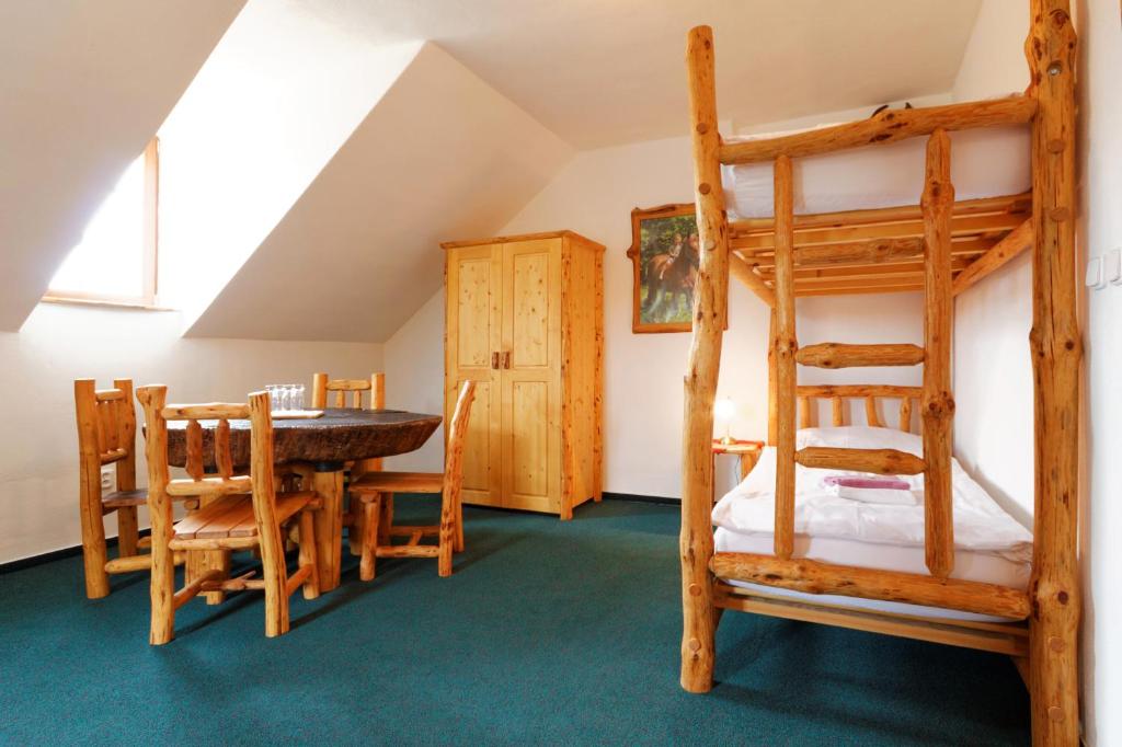 a room with two bunk beds and a table and chairs at Osada Havranů in Hnanice