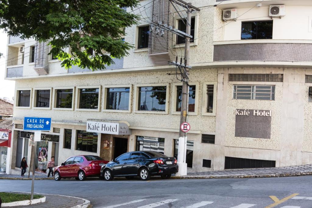 a building with two cars parked in front of it at Kafé Hotel in Guaratinguetá