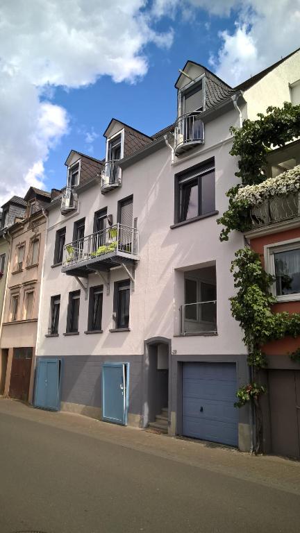 ツェル・アン・デル・モーゼルにあるMosel Ausblickの青いドアと窓のある白い建物