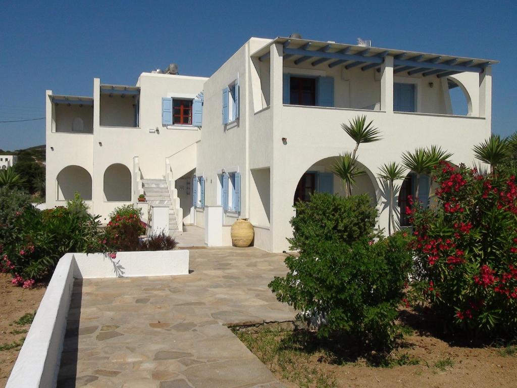 a large white house with a pathway in front of it at Glyfada Beach Studios in Kastraki