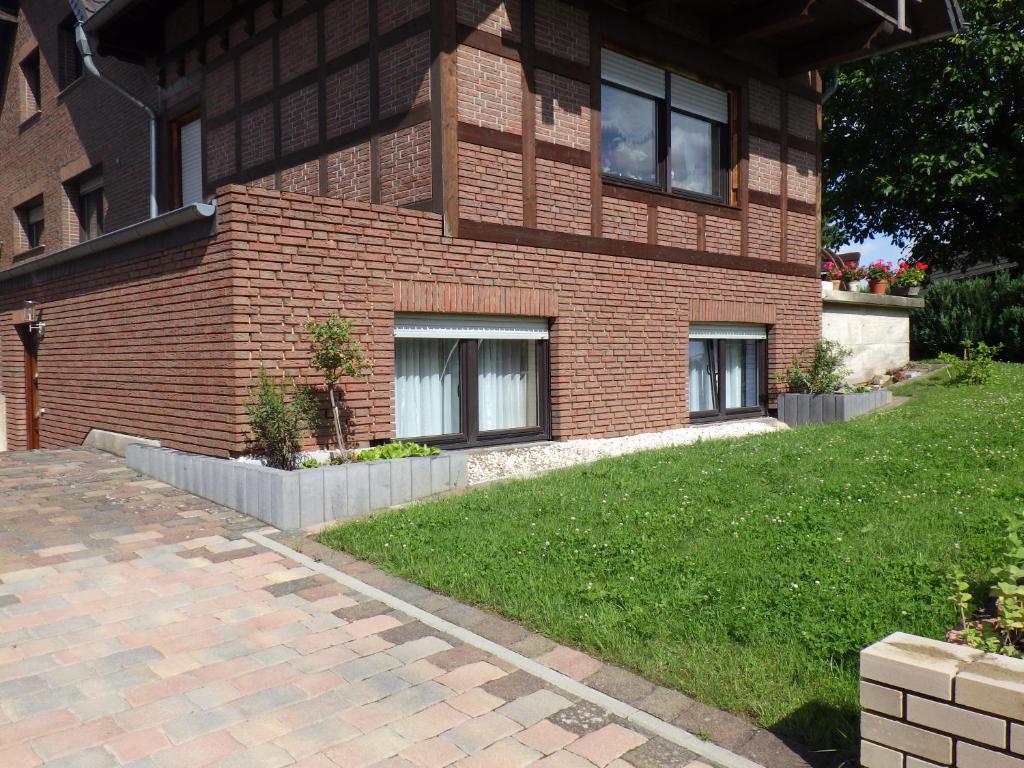 a brick house with a lawn in front of it at Ferienwohnung Kremer in Bad Münstereifel