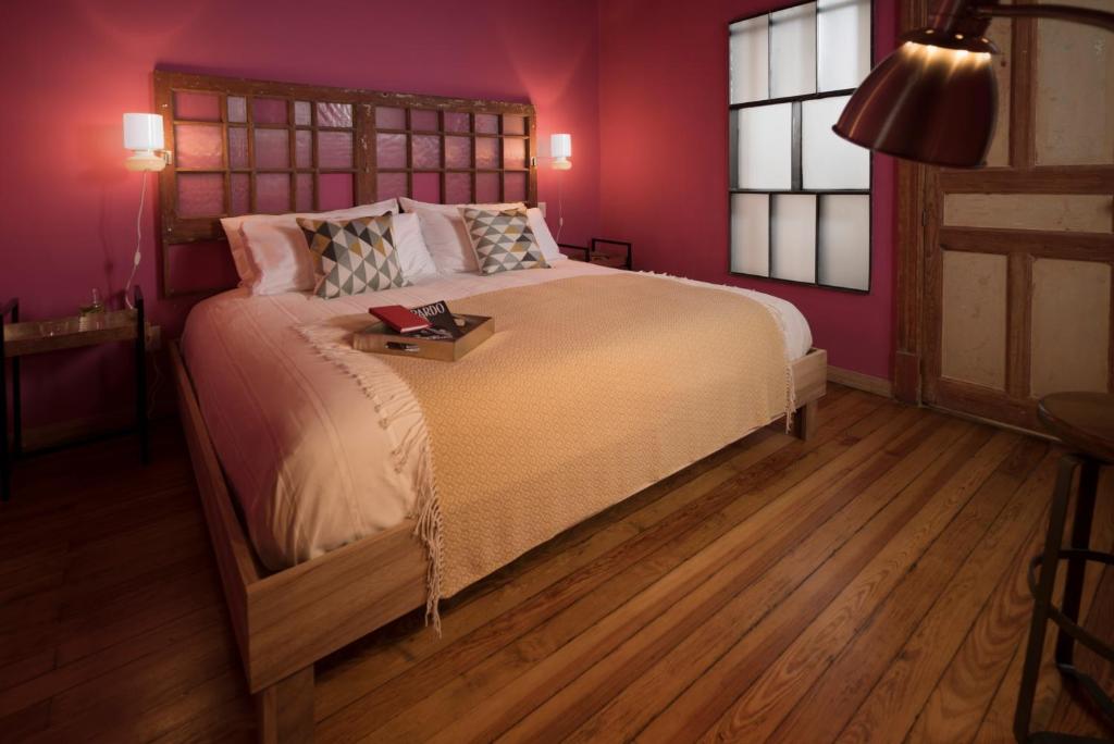 1 dormitorio con 1 cama grande y paredes moradas en Don Jacinto Stay&Sip en Ciudad de México
