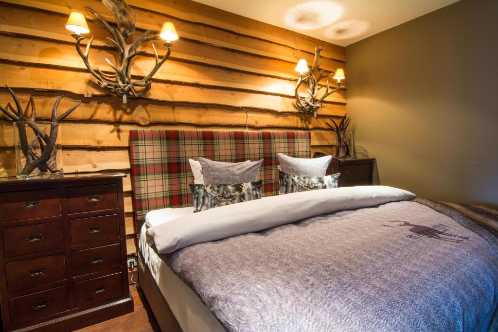 a bedroom with a bed and a wooden wall at Bliss Boutique Hotel in Breda