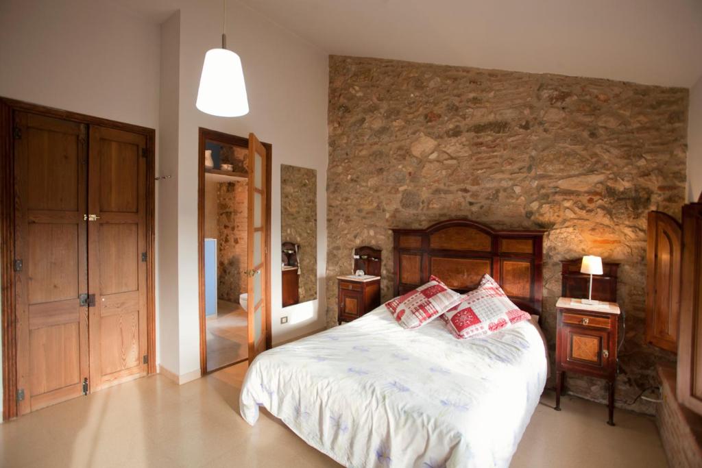 レウスにあるMas del Molíの石壁のベッドルーム1室(ベッド1台付)