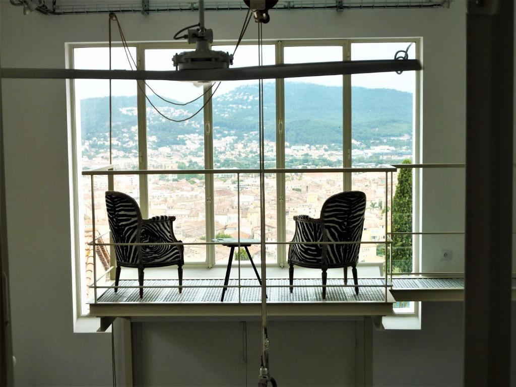 zwei Stühle auf einem Balkon vor einem Fenster in der Unterkunft Grand Loft EM33 in Hyères