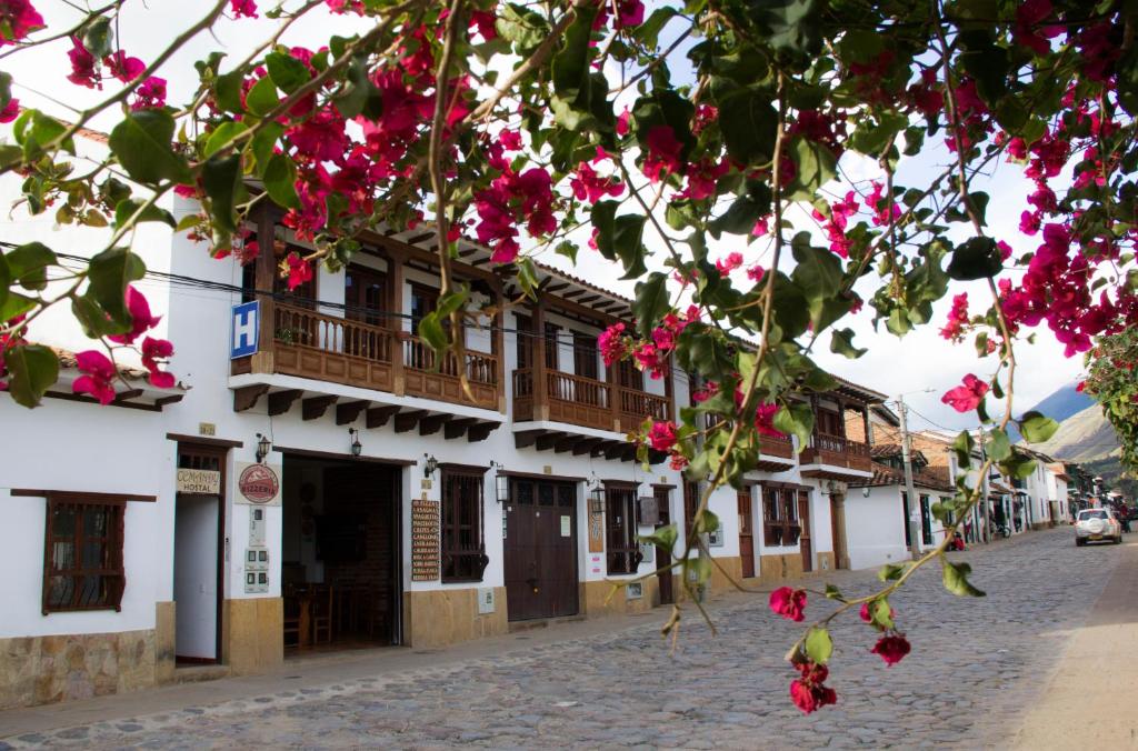 a street with pink flowers in front of a building at Cemandy Hostal in Villa de Leyva