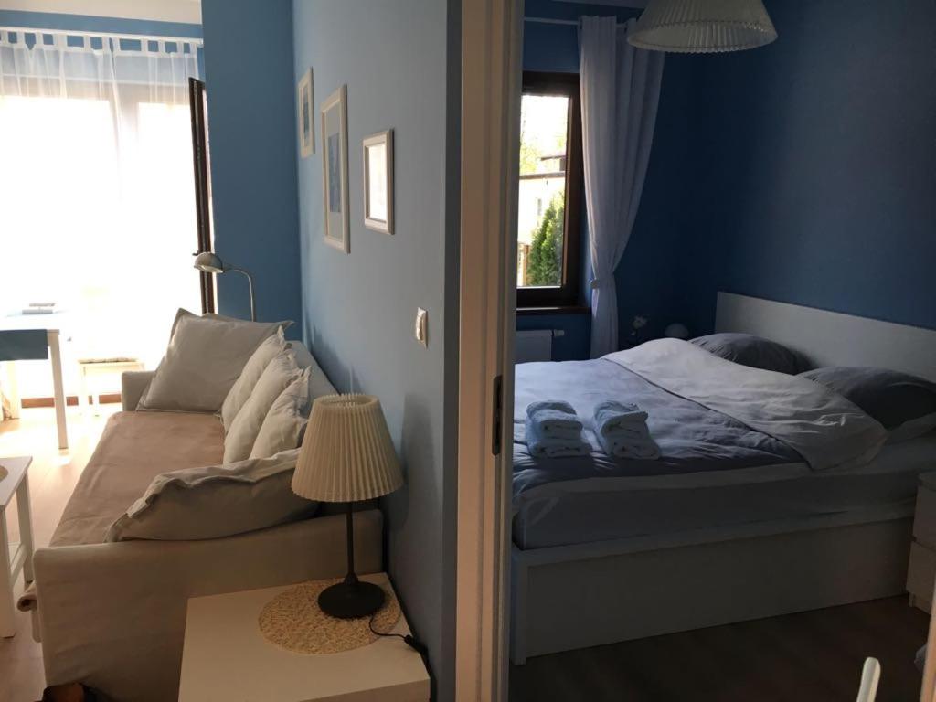 a blue bedroom with a bed and a window at Solankowe Zacisze in Inowrocław