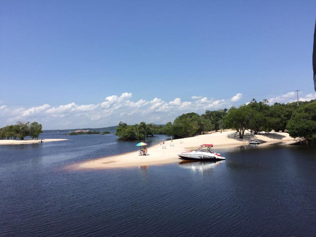 un barco sentado en una playa en el agua en Casa Varanda do Tupé, en Manaus