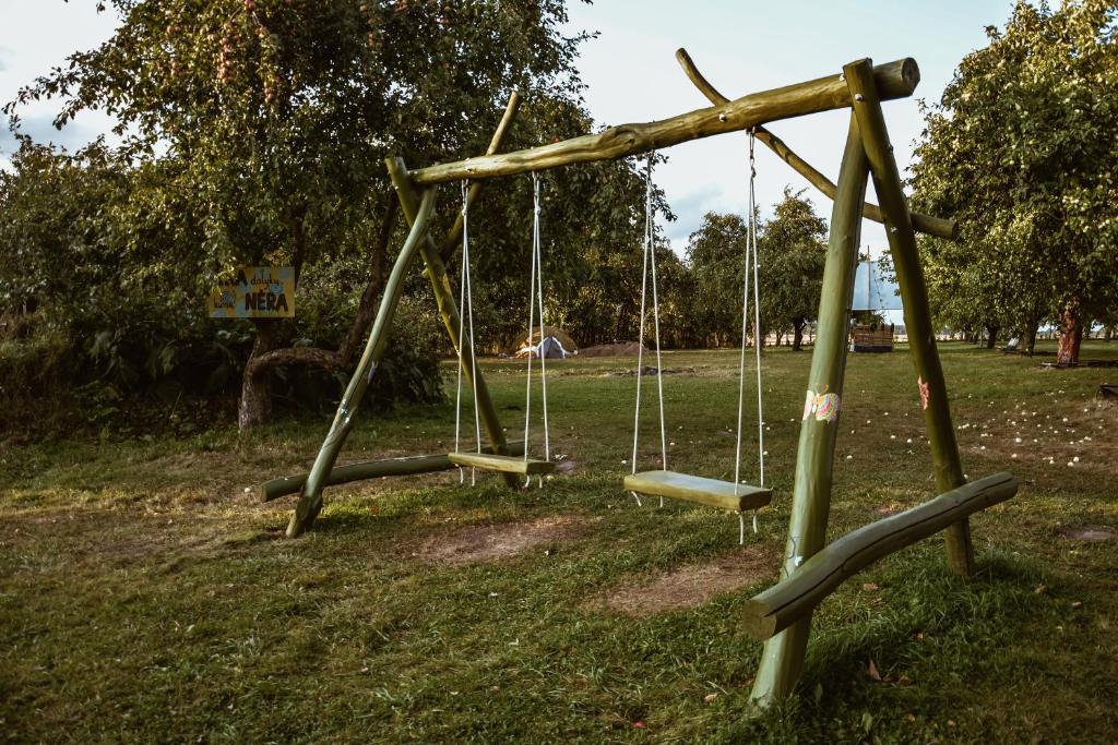 an old swing set in a park at Sunny Nights Homestead Rustic House in Gataučiai
