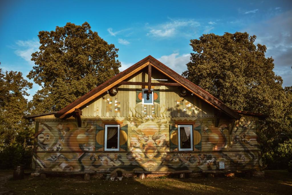 a house with graffiti on the side of it at Sunny Nights Homestead Rustic House in Gataučiai