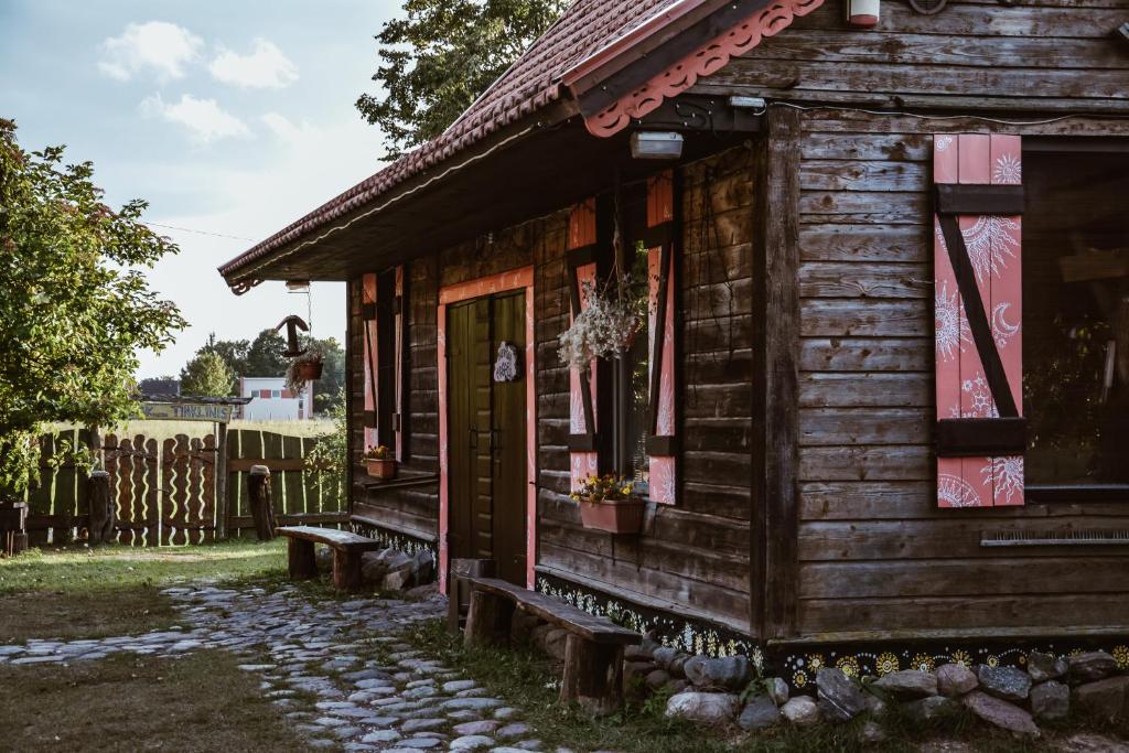 a wooden house with a porch and a door at Sunny Nights Homestead Rustic House in Gataučiai