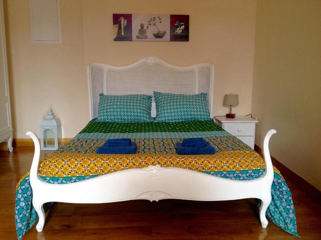 um quarto com uma cama branca e almofadas azuis em Un Joli Pied a Terre em Montignac