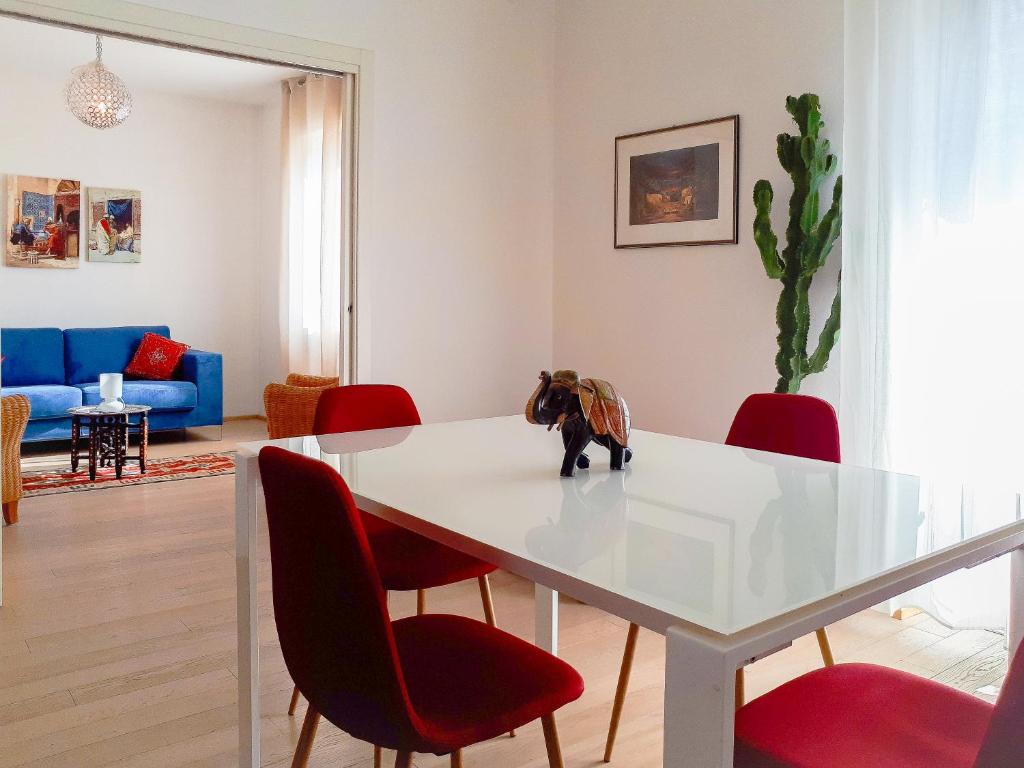 a living room with a white table and red chairs at Casa Musica Sol in Verona
