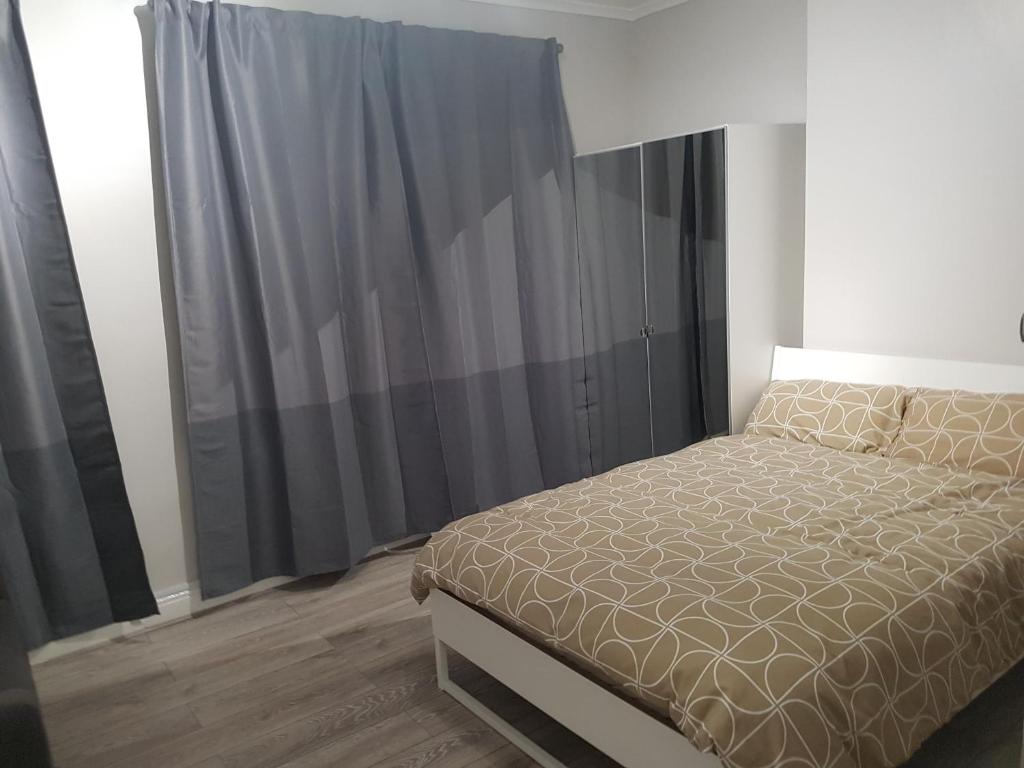 a bedroom with a bed and black curtains at Court Road House in Cardiff