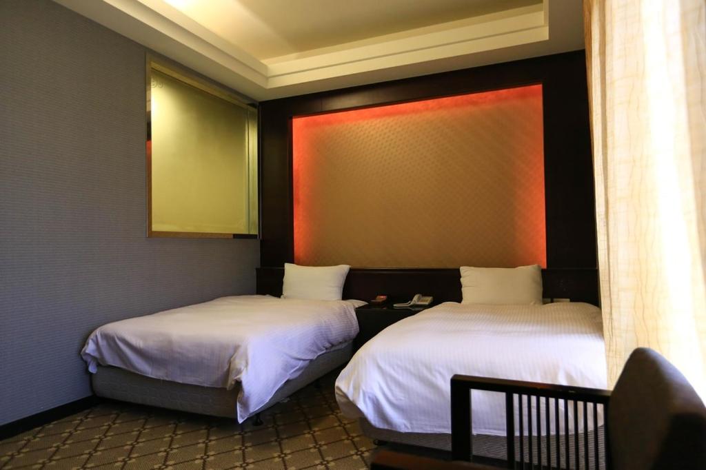 2 camas en una habitación con en Wanli Spa & Resort en Wanli