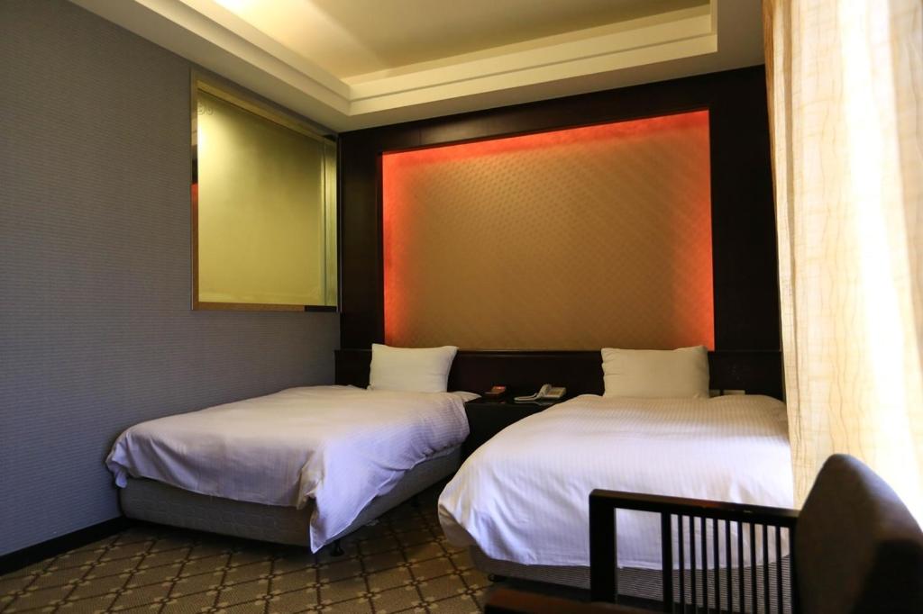 two beds sitting in a room with at Wanli Spa & Resort in Wanli