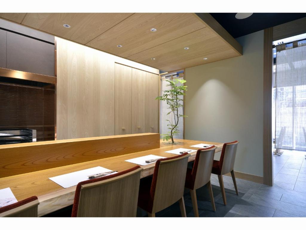 a dining room with a long wooden table and chairs at Hotel Rose Garden Shinjuku in Tokyo