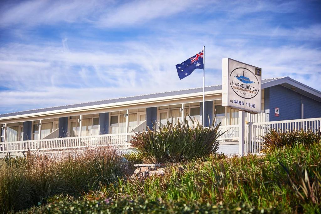 un edificio con una bandera delante de él en Harbour View Apartments en Ulladulla