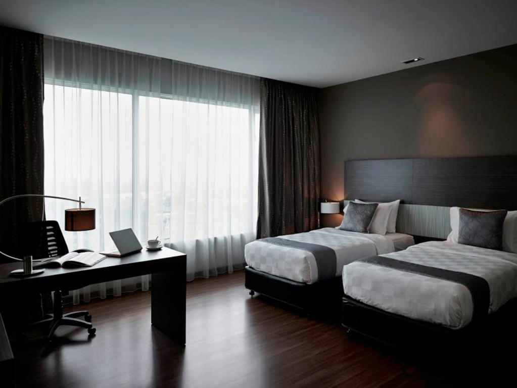 Una cama o camas en una habitación de Pullman Kuching