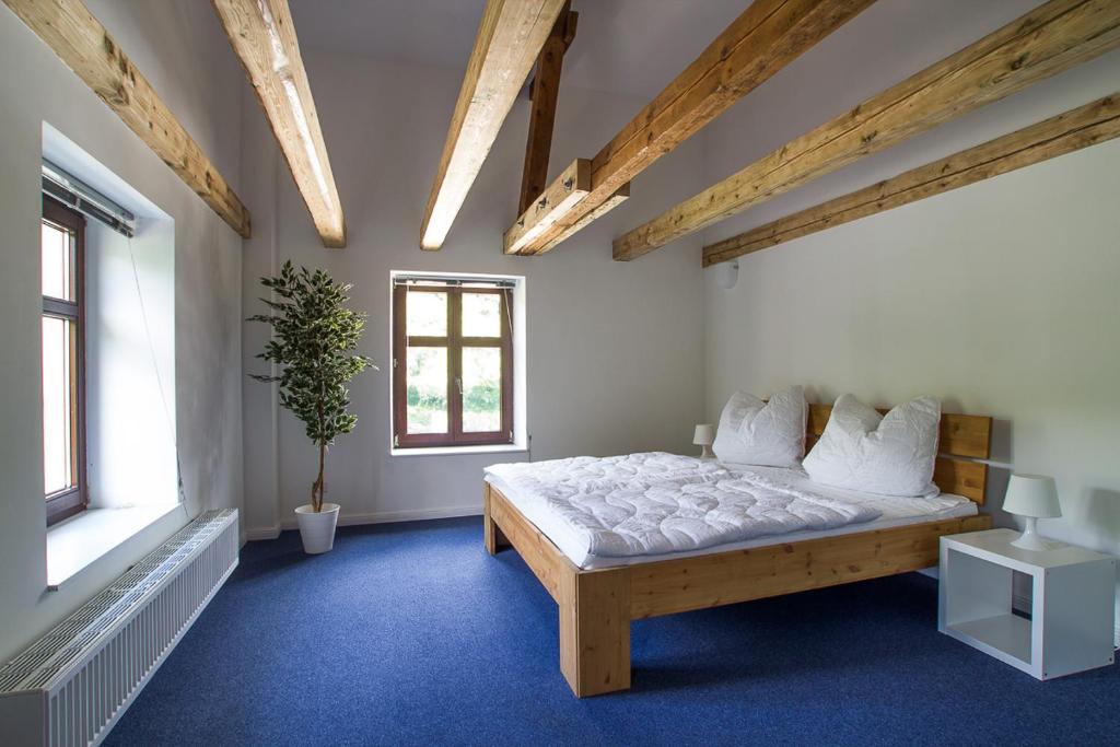 - une chambre avec un grand lit dans une pièce dotée de plafonds en bois dans l'établissement Nostalgischer Kaiserbahnhof, à Bad Doberan