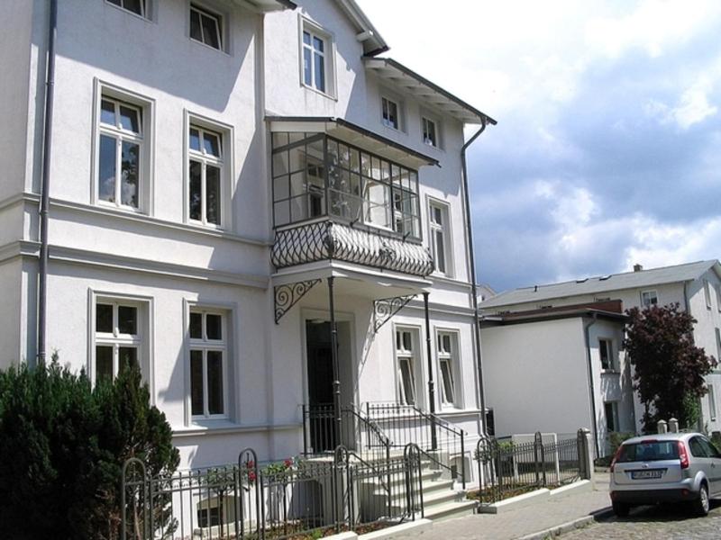 a white house with a balcony on the front of it at Villa Elfriede in Sassnitz