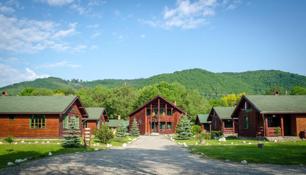 une rangée de cabanes en bois avec une allée dans l'établissement Desag Resort, à Sub Cetate