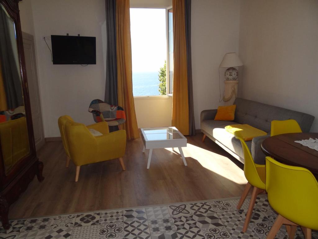 a living room with a couch and yellow chairs at Appartement Colonella in Bastia