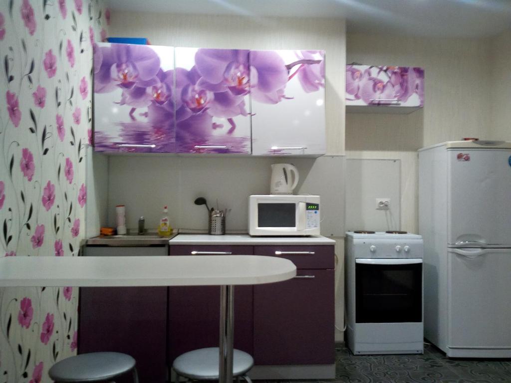 キーロフにあるApartment on Moskovskayaのキッチン(紫色のキャビネット、白い電子レンジ付)