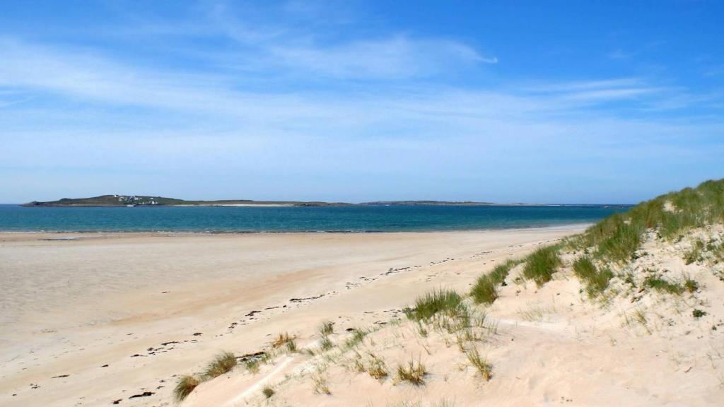 a sandy beach with the ocean in the background at Dal Riada B&B in Gweedore