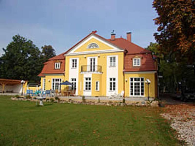 a large yellow house with a red roof at Herrenhaus Poppelvitz in Maltzien