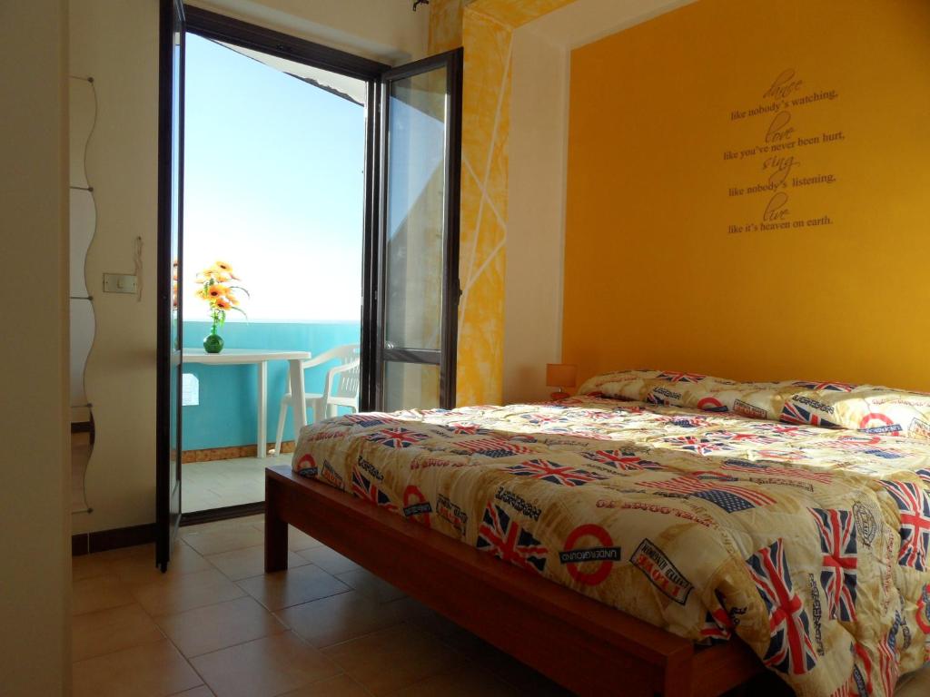 1 dormitorio con cama y ventana grande en Appartamento San Martino, en Copanello