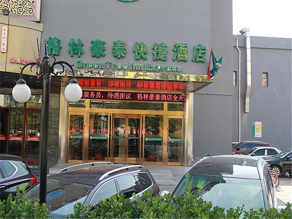 a store with cars parked in front of it at GreenTree Inn Tianjin Xiqing District Xiuchuan Road Sunshine 100 in Tianjin