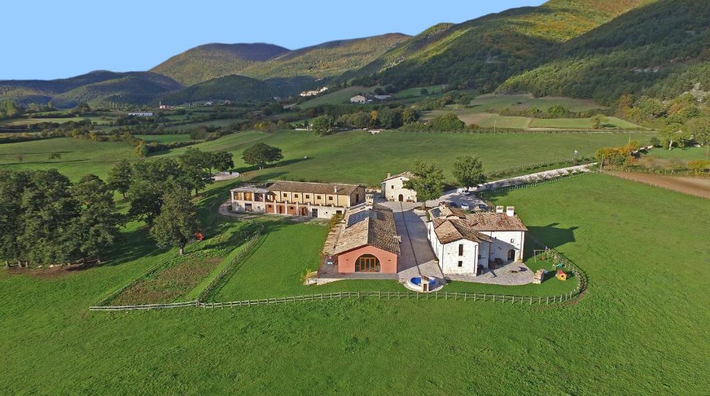 an aerial view of a house in a green field at Agriturismo Casale Montebello in Monteleone di Spoleto