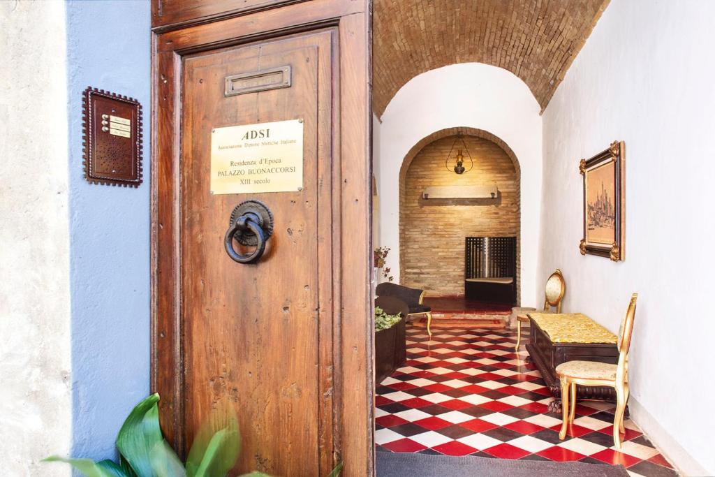 eine Tür zu einem Zimmer mit einem karierten Boden in der Unterkunft Residenza D'Epoca Palazzo Buonaccorsi in San Gimignano