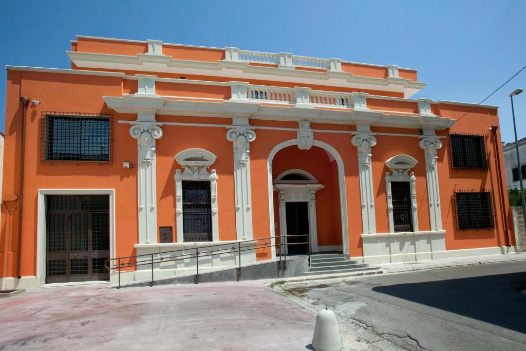 un edificio arancione con colonne e arco di Domus Salentina a Leverano