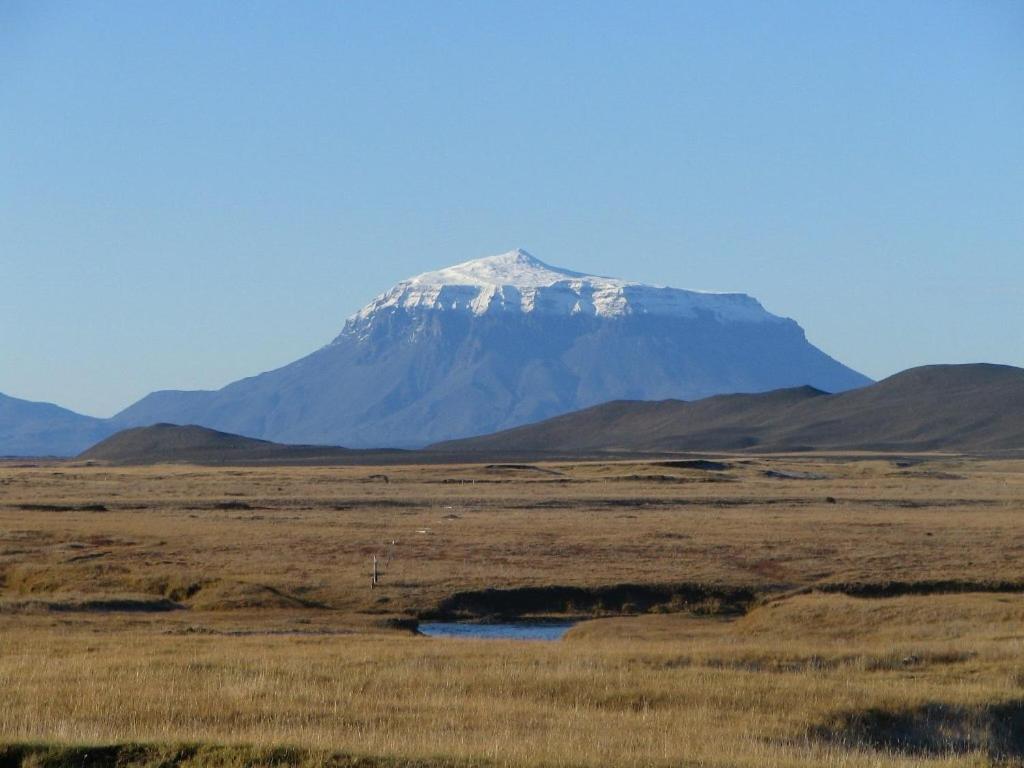 a mountain in the middle of a field at Fjalladýrð Guesthouse in Modrudalur