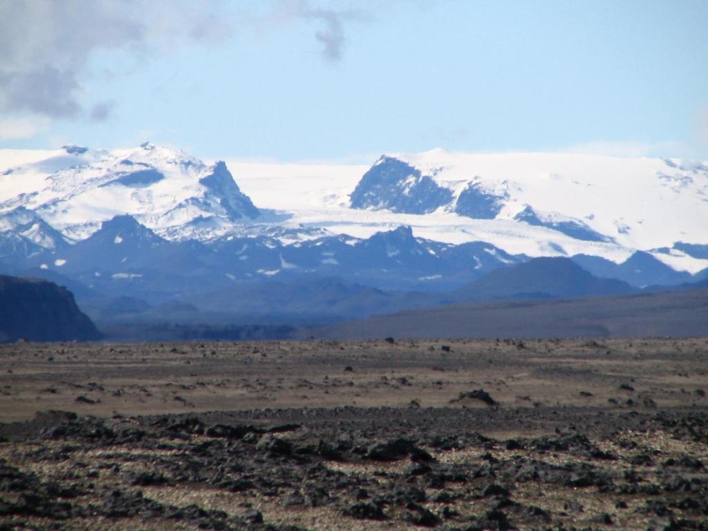 a snow covered mountain in the middle of a field at Fjalladýrð Guesthouse in Modrudalur