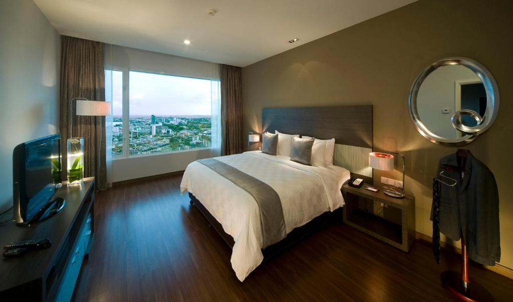 Una cama o camas en una habitación de Pullman Kuching
