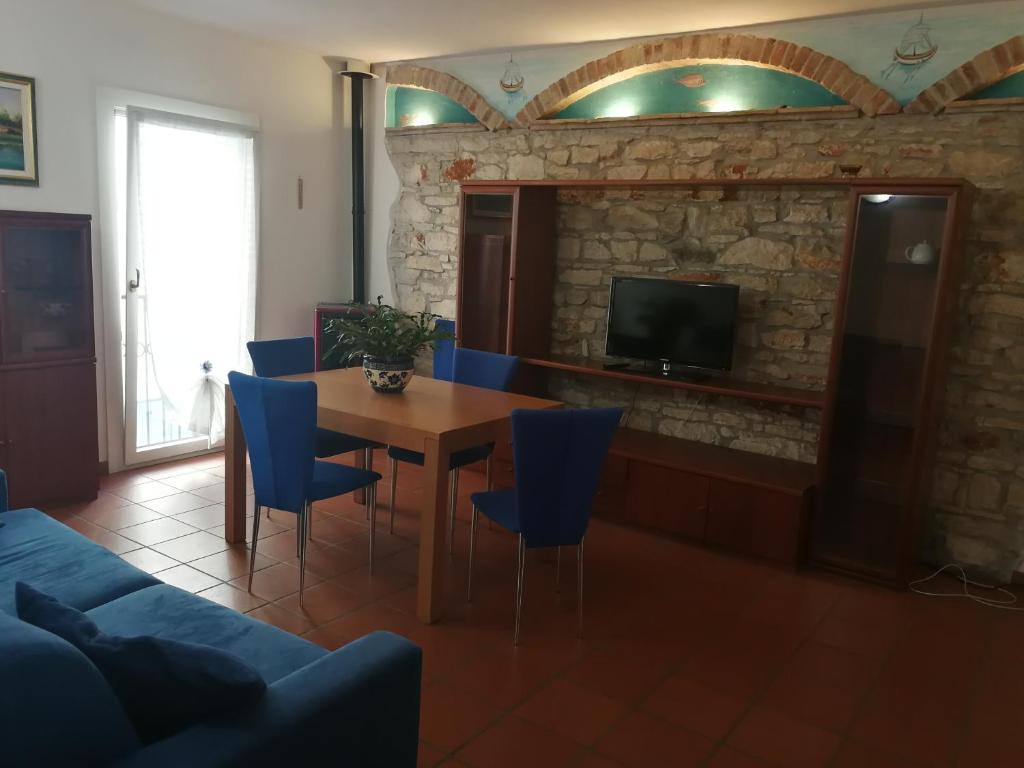 グラードにあるGrado Exclusive Apartmentのリビングルーム(木製テーブル、青い椅子付)