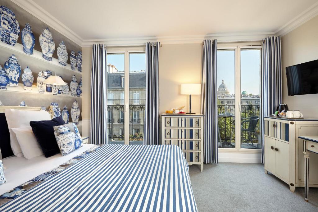 um quarto azul e branco com uma cama e uma janela em Relais Saint Jacques em Paris