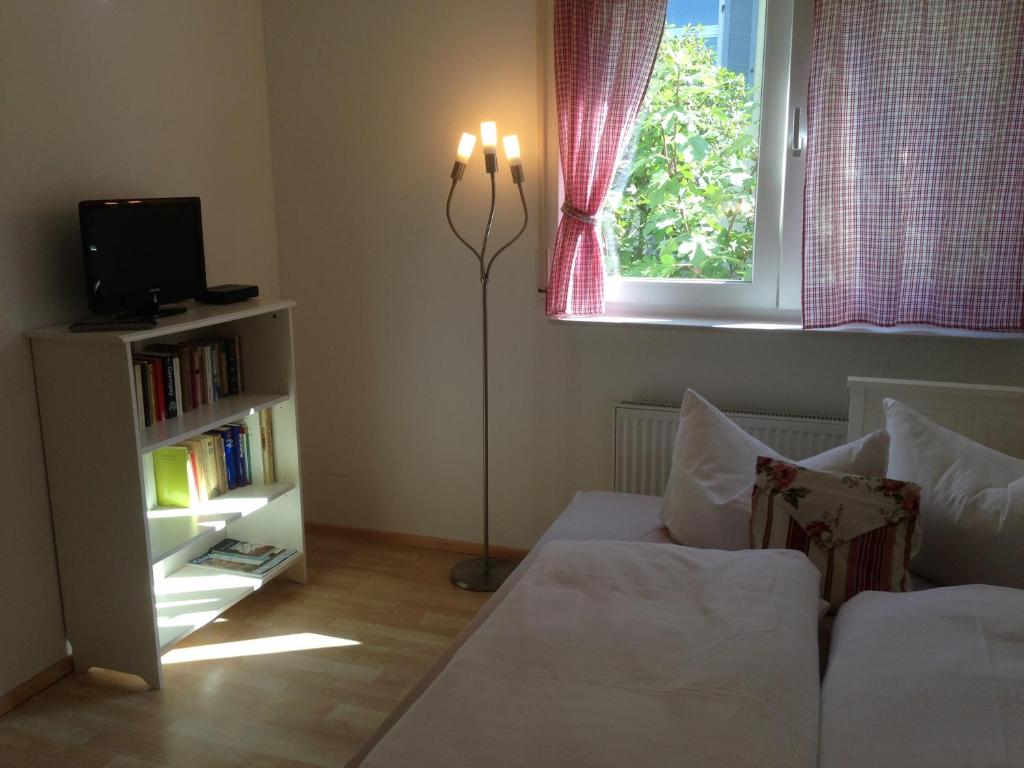 a bedroom with a bed and a window and a book shelf at Petite Bellevue II in Baden-Baden
